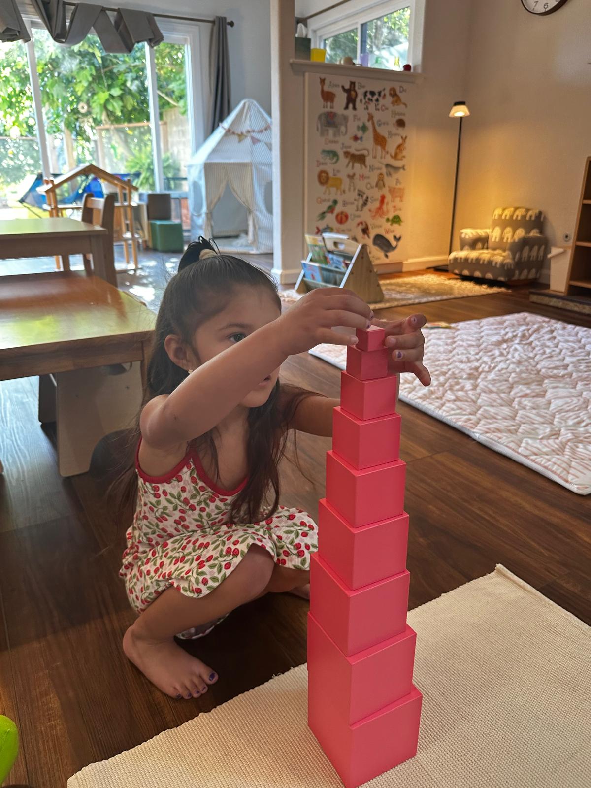 Child building the Montessori pink tower